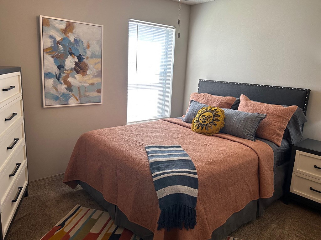 a bedroom with a bed and a painting on the wall