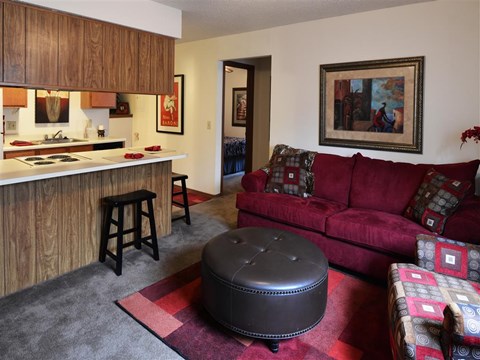 a living room with a red couch and a kitchen