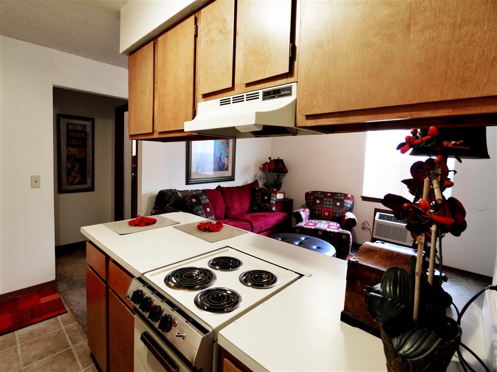 a kitchen with a stove top oven next to a living room