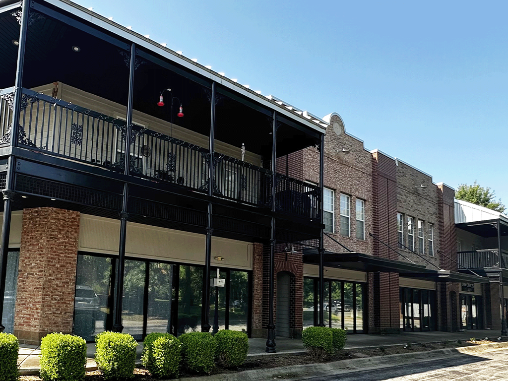 a brick building with glass windows and a balcony