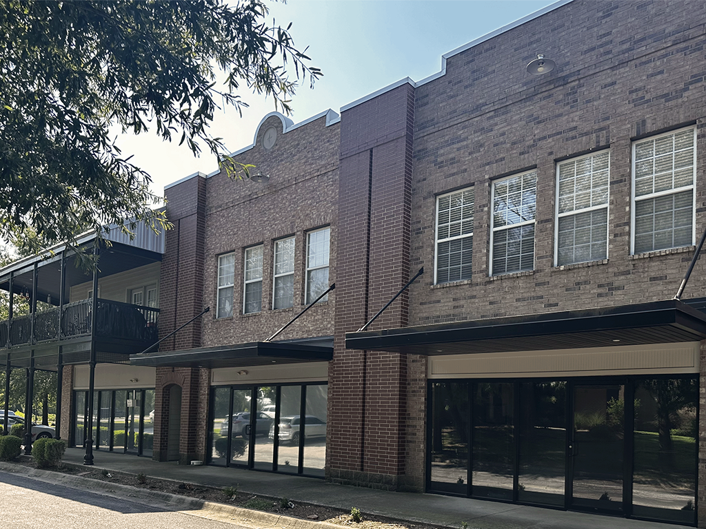 the front of a brick building with glass windows