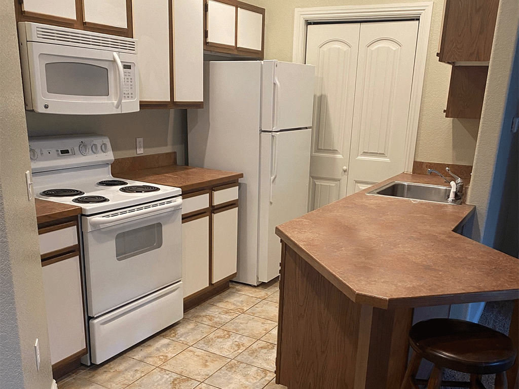 a kitchen with white appliances and a counter top