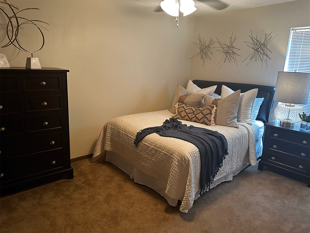 a bedroom with a bed and two dressers