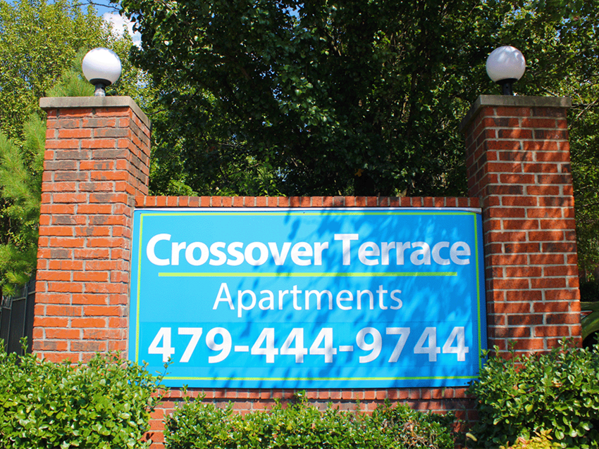a sign for crossover terrace apartments on a brick wall