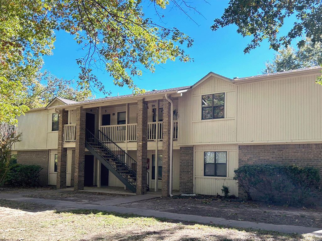 the front of an apartment building with stairs and a sidewalk