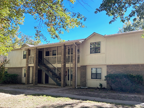 the front of an apartment building with stairs and a sidewalk