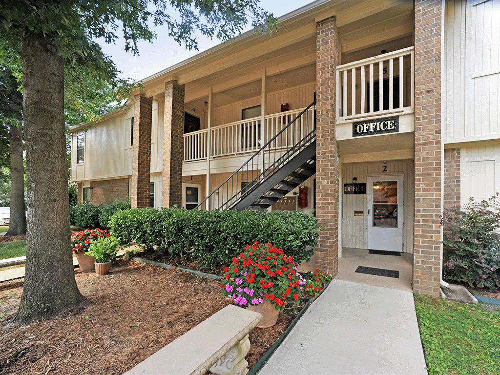 an apartment building with a staircase and a porch with flowers