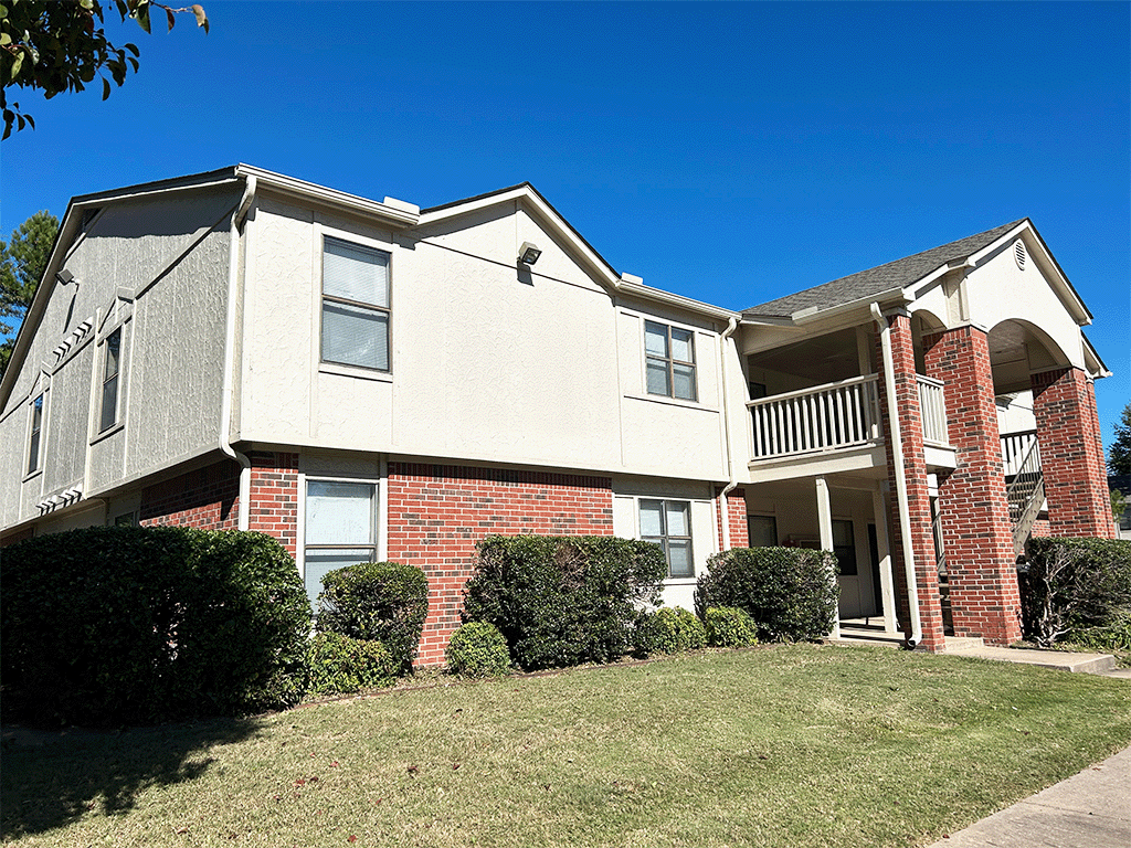 an apartment building with a lawn in front of it