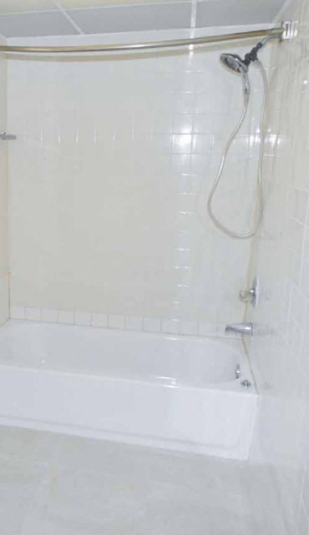 a white bath tub sitting next to a shower