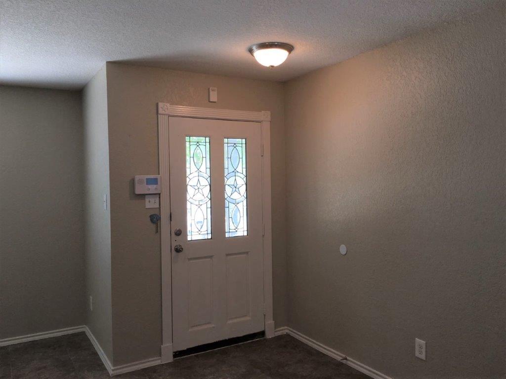 an empty room with a door and a light on the ceiling