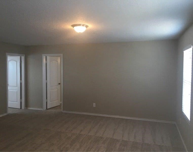 an empty living room with a light on the ceiling