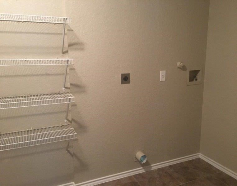 an empty closet with two shelves and two lights on the wall