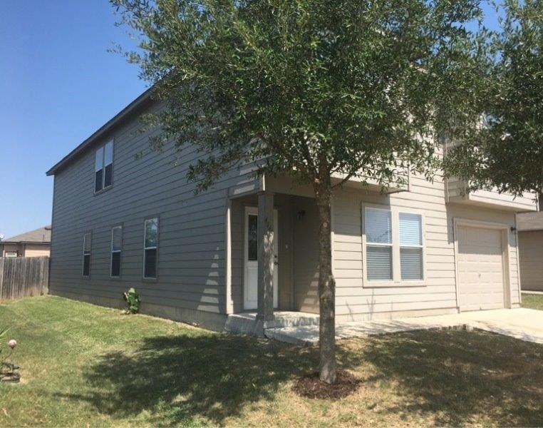 a white house with a tree in front of it