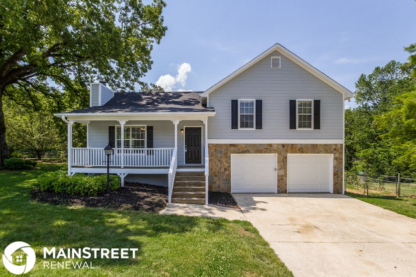 a white house with a porch and a white garage door