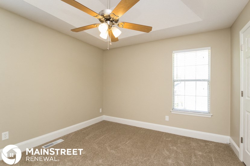 a bedroom with a ceiling fan and a window
