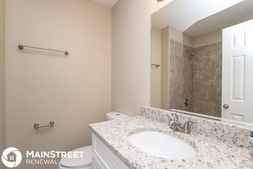 a bathroom with a sink and a shower and a mirror