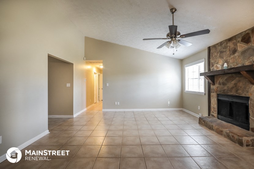 a living room with a fireplace and a ceiling fan