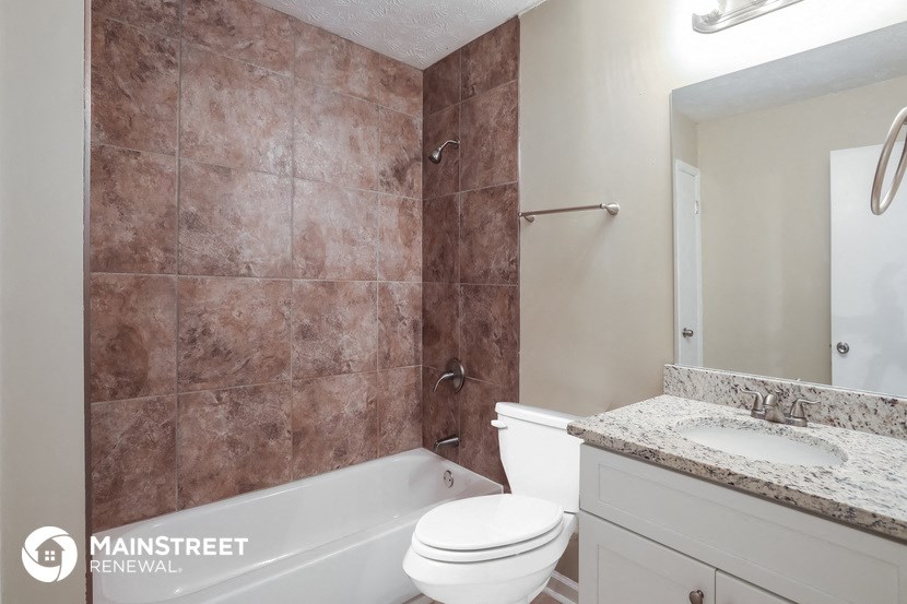 a bathroom with a toilet and a tub and a sink