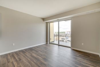 Large open dining and living area with hardwood style flooring at Ascend at Woodbury in Woodbury, MN