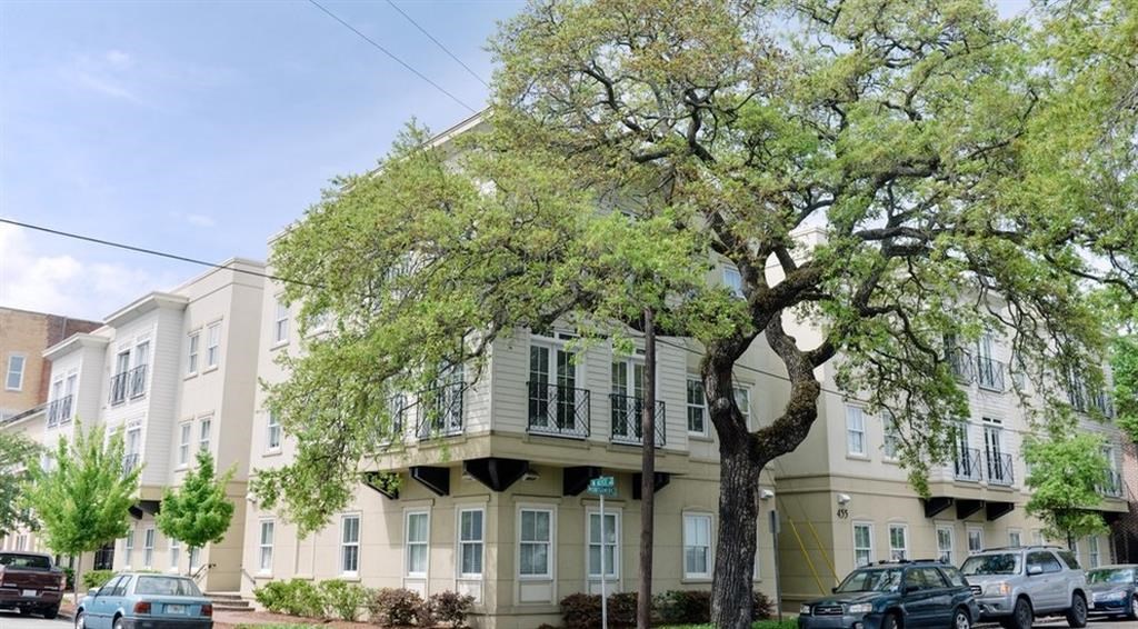 a large apartment building with cars parked in front of it
