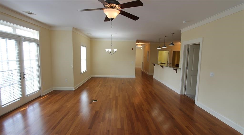 an empty living room with a ceiling fan