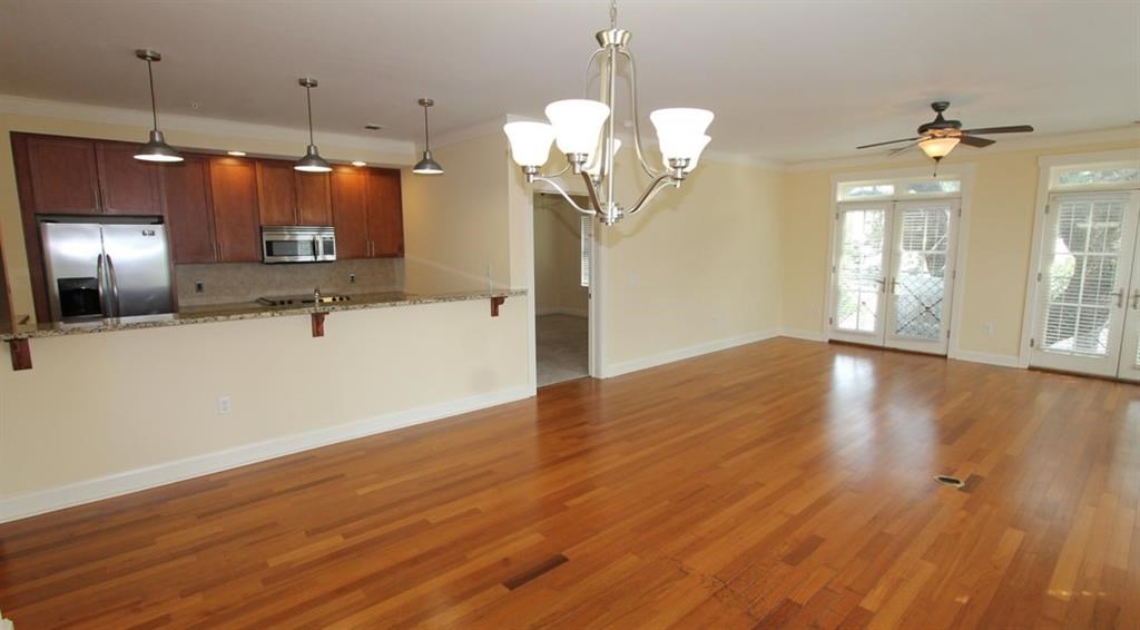 an empty living room and kitchen with a wood floor