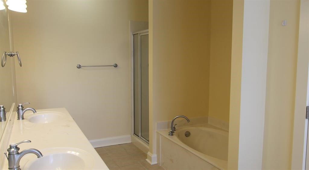 a bathroom with two sinks and a tub and a shower