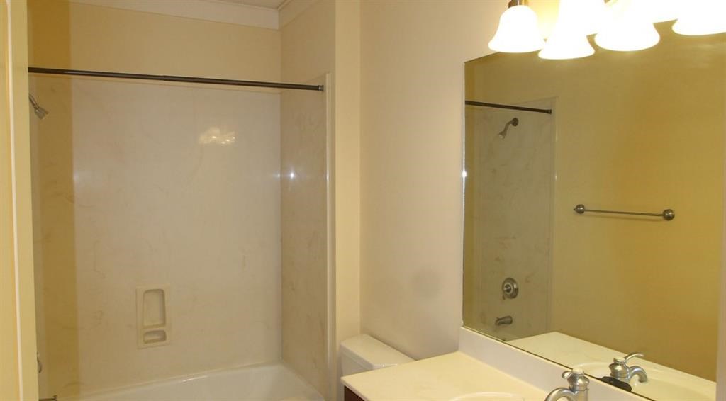 a bathroom with a shower and a sink and a mirror