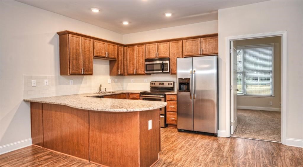 a kitchen with wooden cabinets and a stainless steel refrigerator
