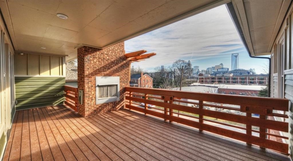 a large deck with a fireplace and a view of the city