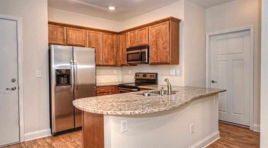 a kitchen with granite counter top and stainless steel refrigerator