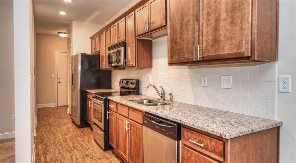 a kitchen with wooden cabinets and a sink and a refrigerator