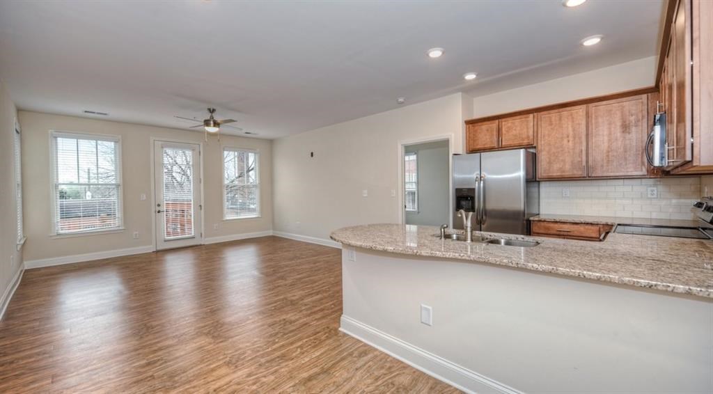 an empty living room and kitchen with a counter top