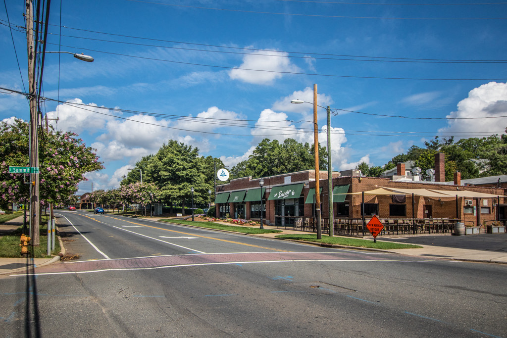 an empty street in a town with an old building on the corner