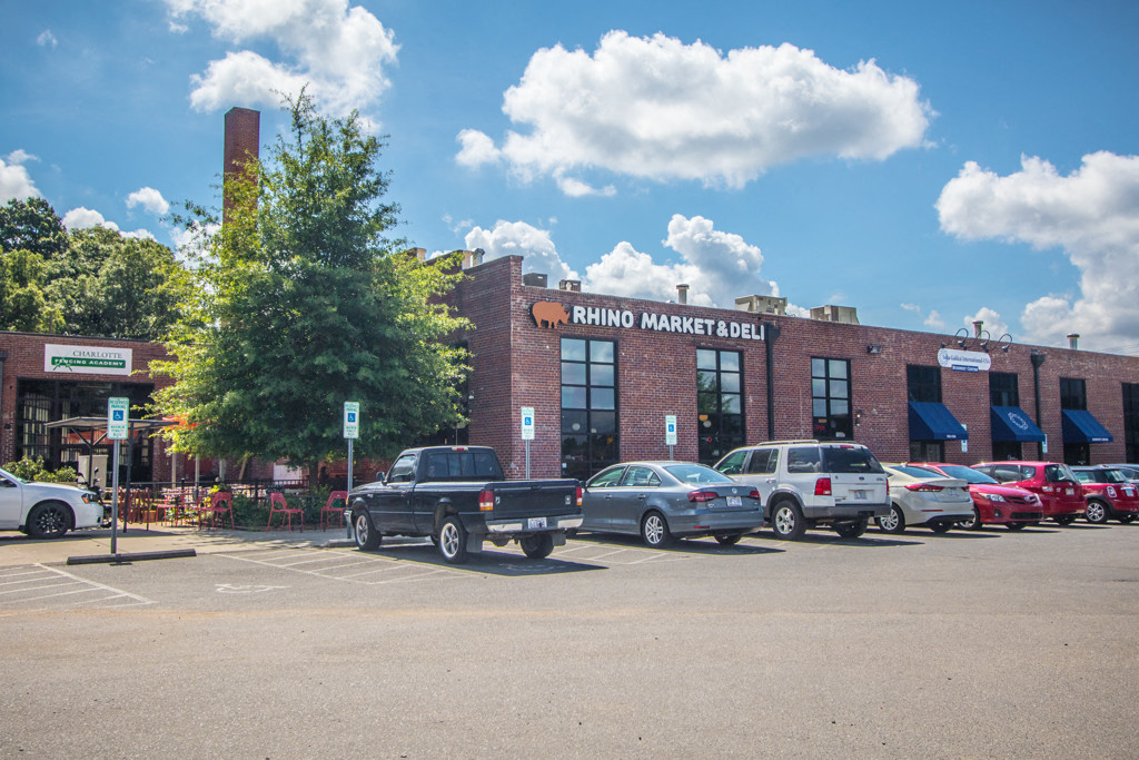 a parking lot filled with cars in front of a brick building
