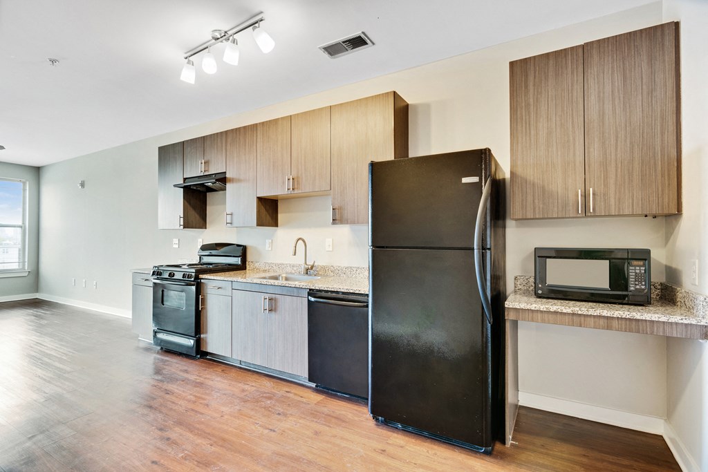 an empty kitchen with stainless steel appliances and wooden cabinets