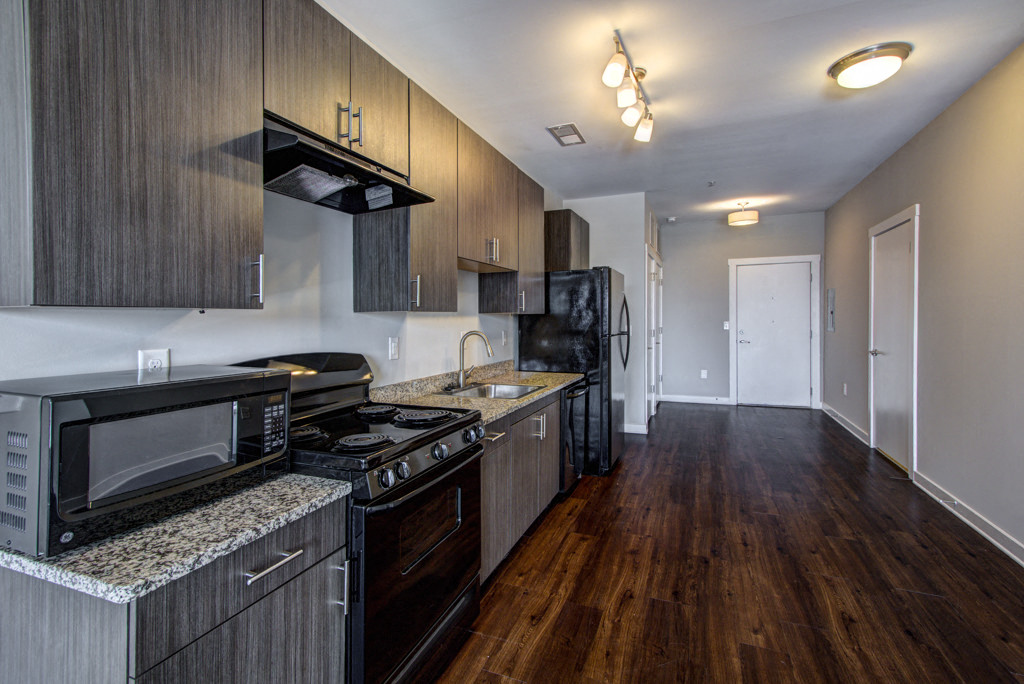 a kitchen with wood flooring and stainless steel appliances and