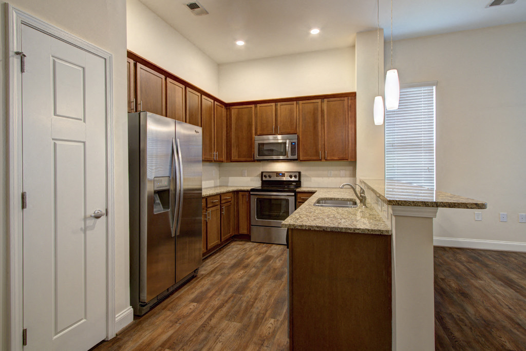 a kitchen with wooden cabinets and stainless steel appliances