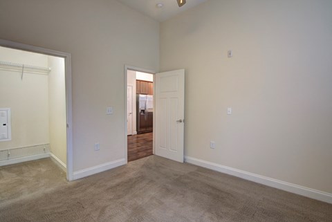 a living room with carpet and a door to a bedroom