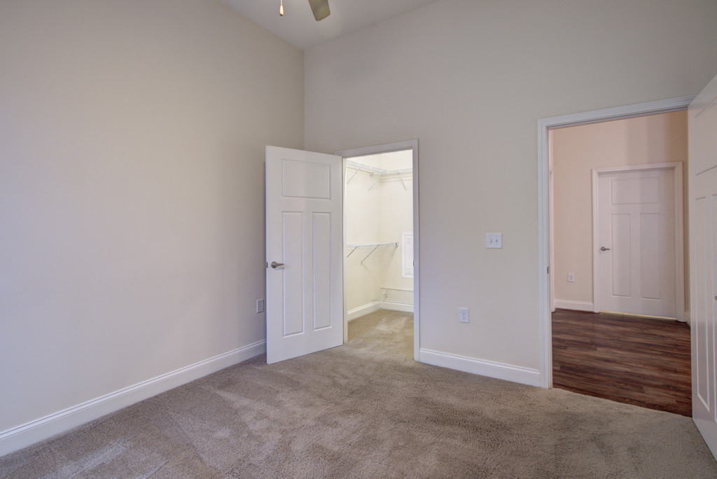 a bedroom with an open door and a carpeted floor
