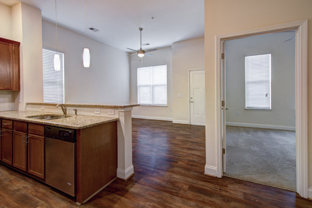 an empty kitchen and living room with a door to the living room
