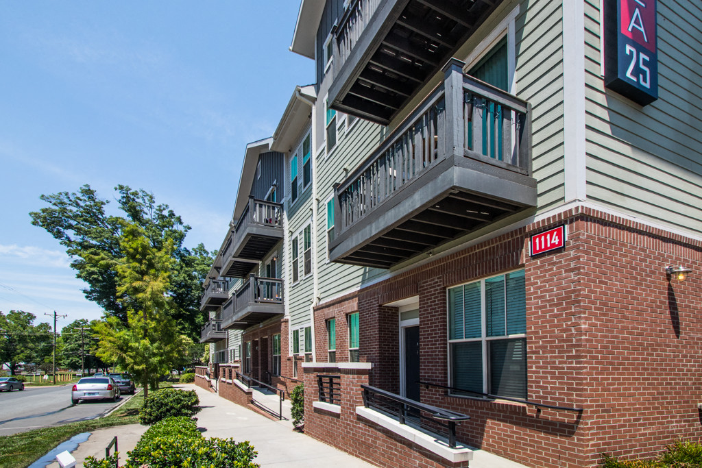 an apartment building with a red and white facade and a sign that reads a24