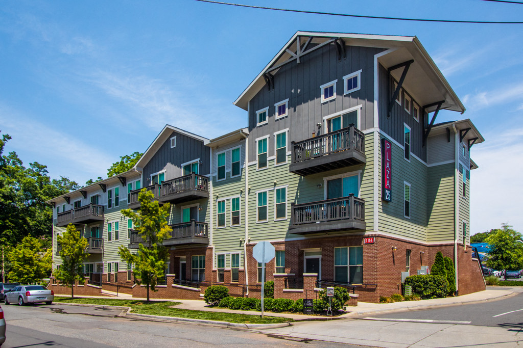 an apartment building on a street corner with a stop sign