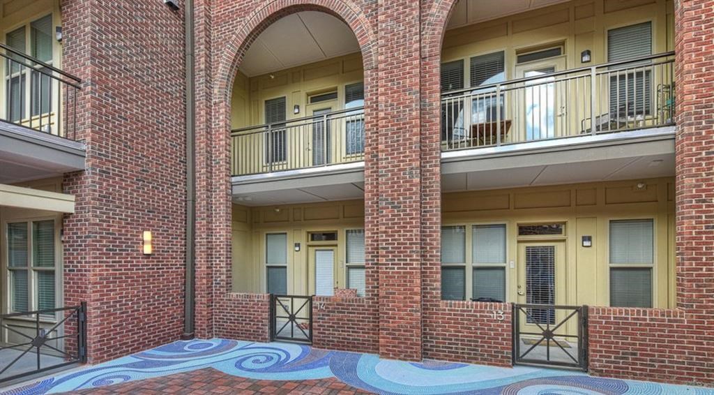 a red brick building with two balconies and a blue rug on the floor