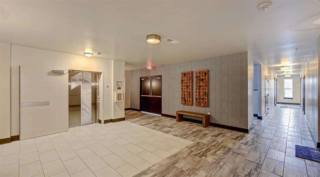 a lobby with a white tiled floor and doors