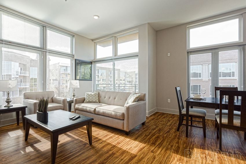 a living room with large windows and a couch and a table