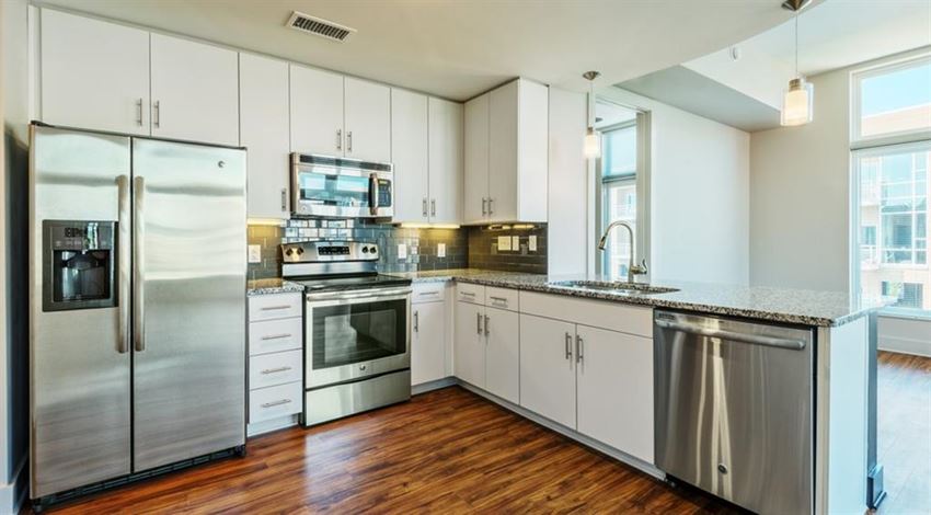 a kitchen with white cabinets and stainless steel appliances