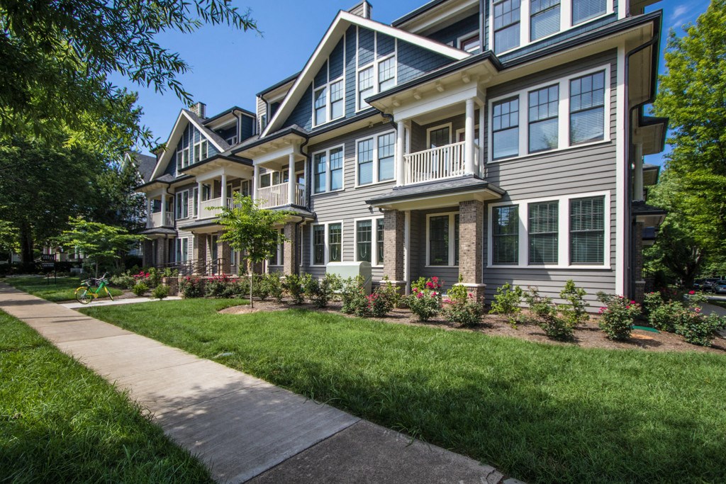 a row of townhomes with a sidewalk in front of them