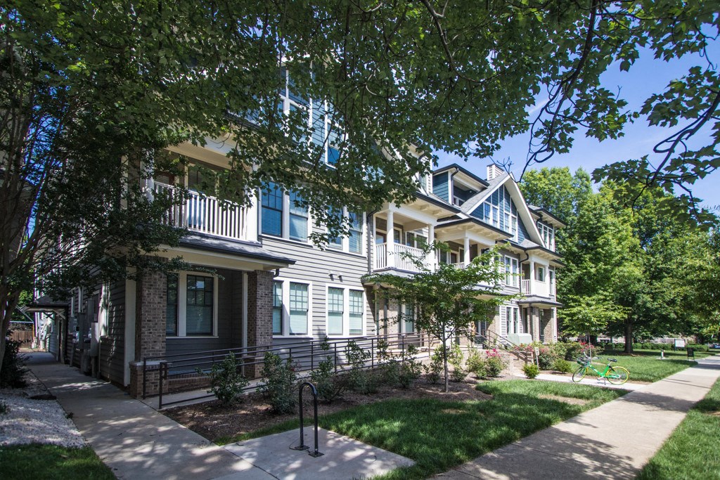 a row of houses with a sidewalk in front of them