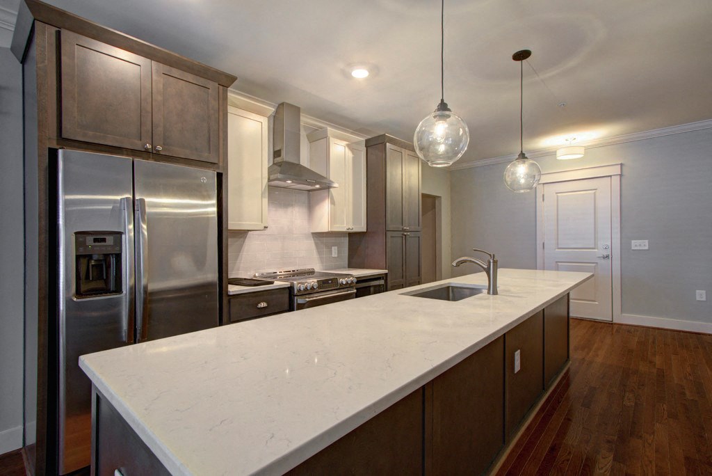 a large kitchen with a large island and stainless steel appliances